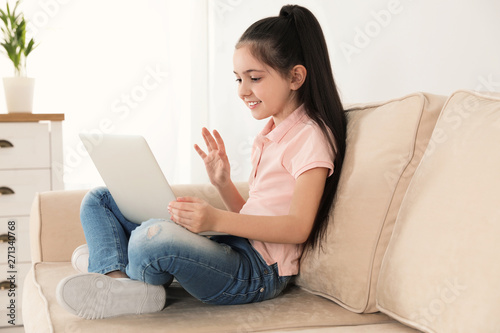 Little girl using video chat on laptop at home
