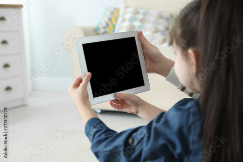 Mother and her daughter using video chat on tablet at home. Space for text