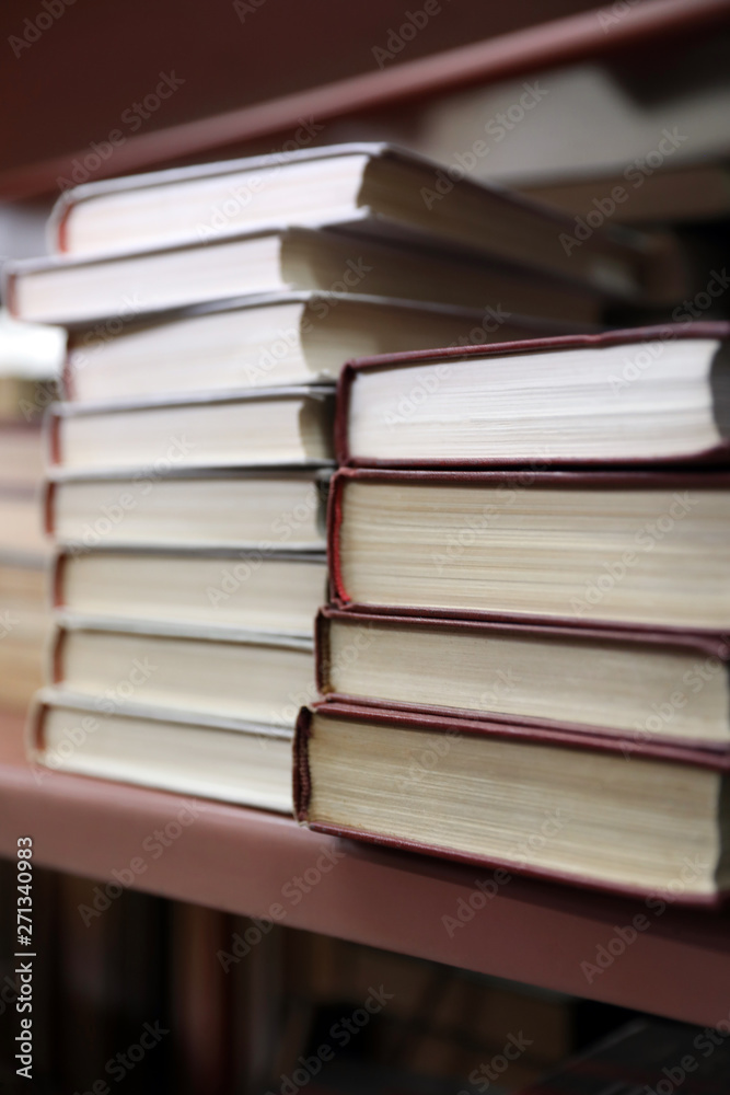 Stacks of books on shelf in library Stacks of books on shelf in library