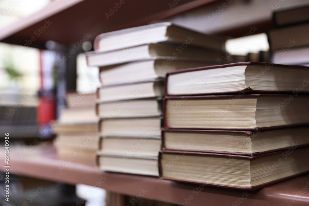 Stacks of books on shelf in library Stacks of books on shelf in library