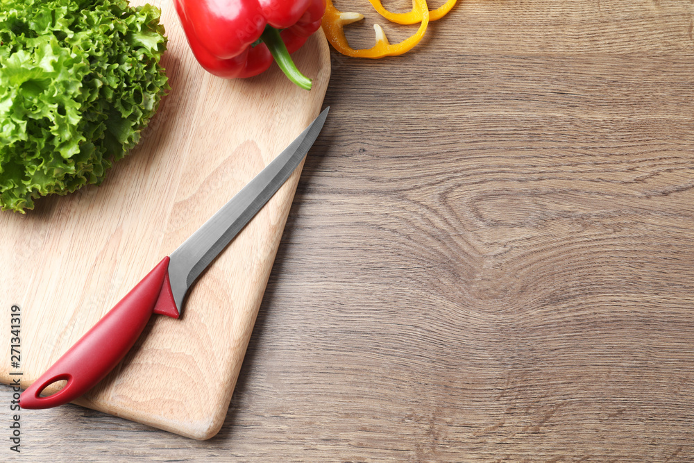 Flat lay composition with sharp knife and space for text on wooden background Flat lay composition with sharp knife and space for text on wooden background