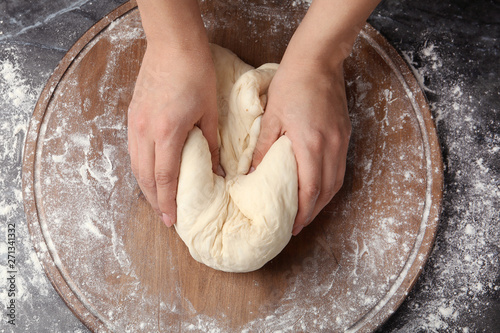 Female baker preparing bread dough at table, top view