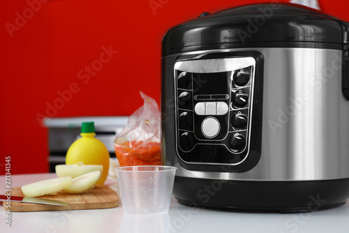 New modern multi cooker and products on table in kitchen