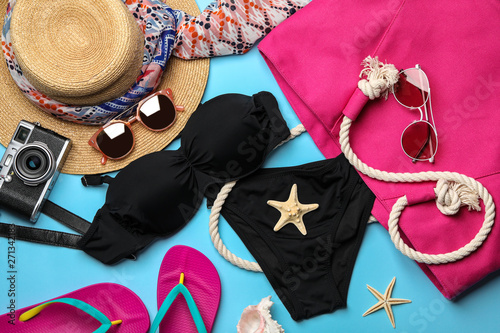 Flat lay composition with swimsuit and beach accessories on color background