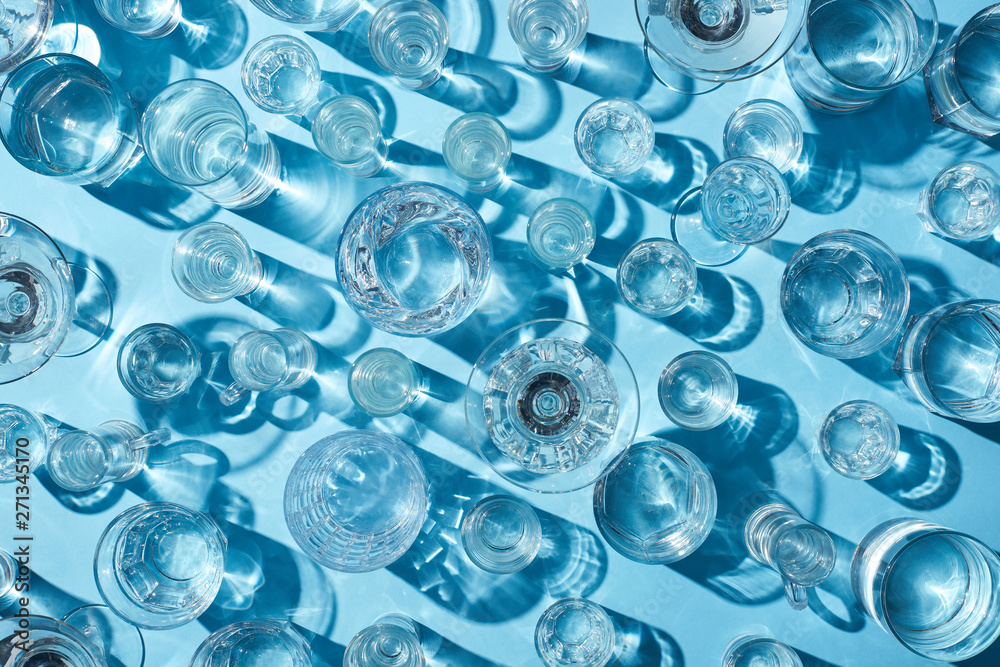 top view of glasses with transparent water on white surface