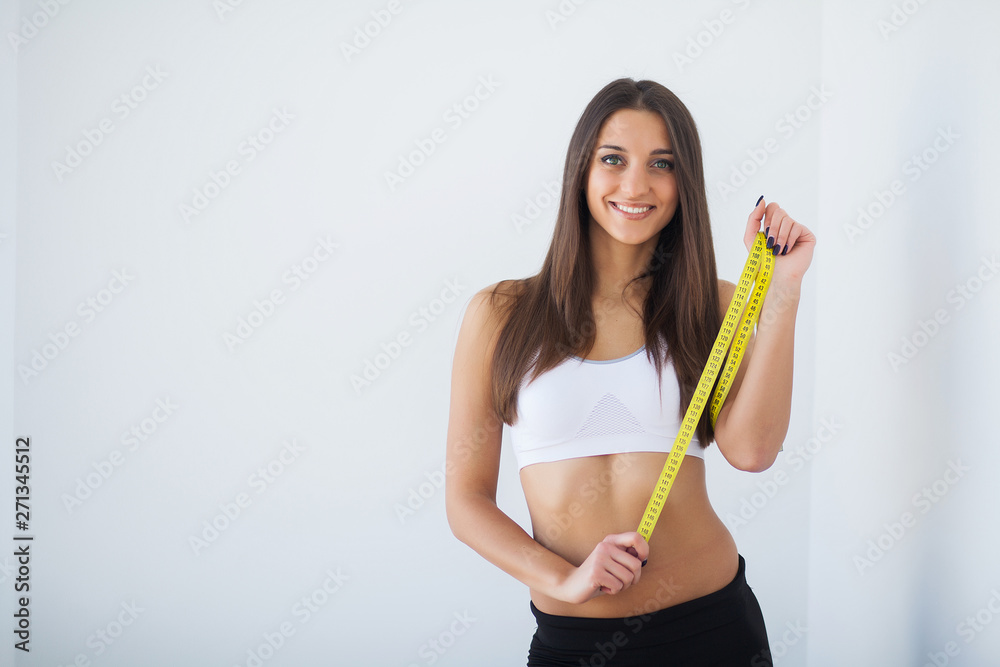 Diet. The girl taking measurements of her body, white background Diet. The girl taking measurements of her body, white background