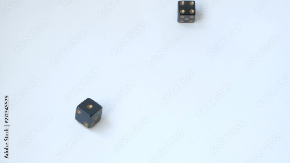 Rolling a four and a one with a pair of black gambling dice on a table in slow motion Rolling a four and a one with a pair of black gambling dice on a table in slow motion