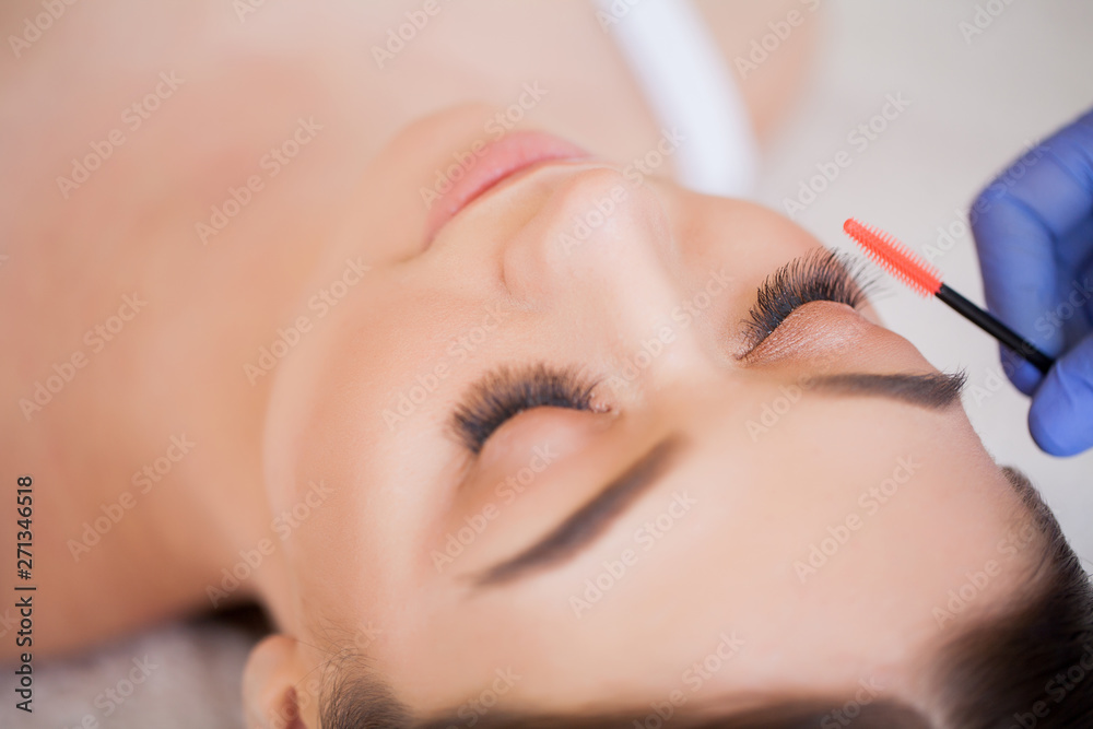 Eyelashes extensions. Fake Eyelashes. Eyelash Extension Procedure. Professional stylist lengthening female lashes. Master and a client in a beauty salon