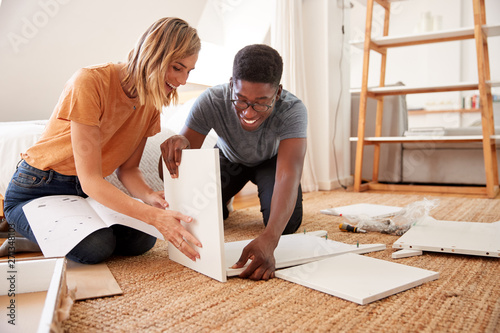 Couple In New Home Putting Together Self Assembly Furniture photo