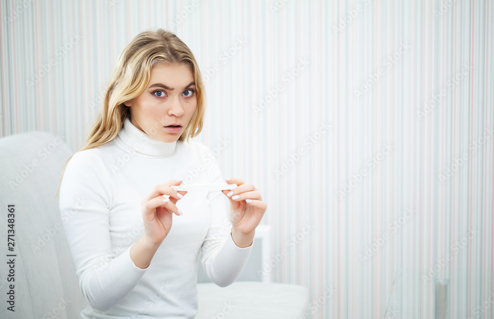 Positive pregnancy test. Portrait of desperate young woman holding pregnancy test stick Positive pregnancy test. Portrait of desperate young woman holding pregnancy test stick