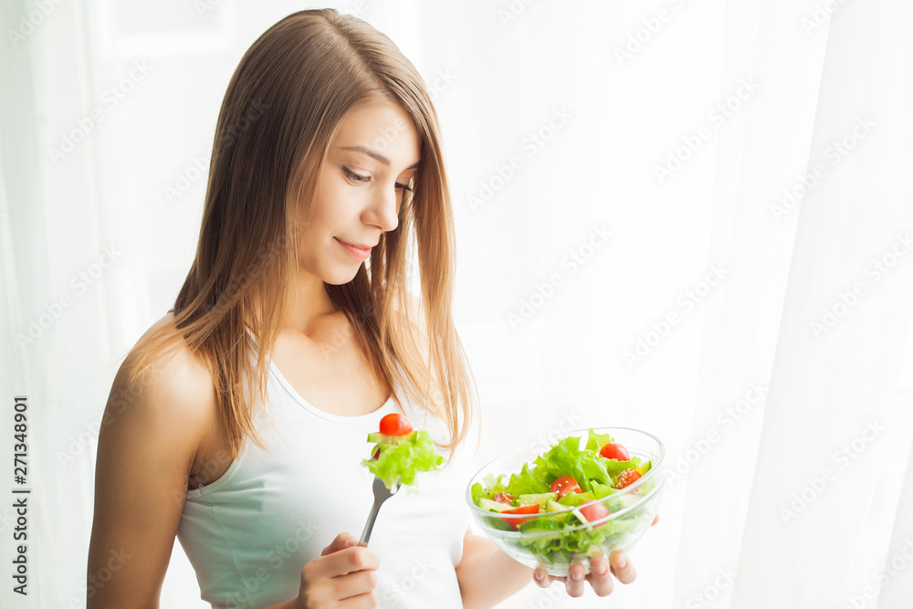 Diet. Young woman eating salad and holding a mixed salad Diet. Young woman eating salad and holding a mixed salad