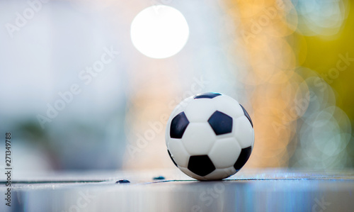 The soccer ball is placed on a wooden floor and has a blurred background with beautiful bokeh.