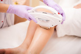 Skin Care. Hair removal on the legs, laser procedure at clinic. Beautician removes hair on beautiful female legs using a laser