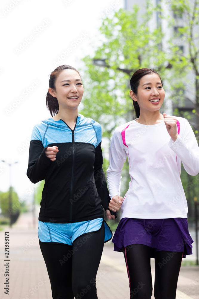 Obraz premium 市街地をウォーキングする女性2人