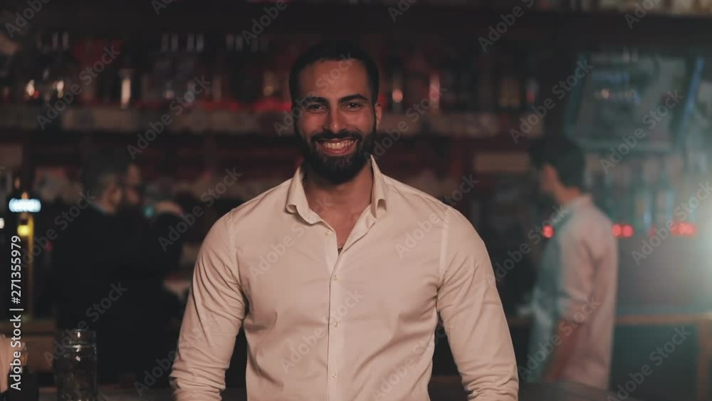 Portrait of smiling attractive man looking at camera in a bar or beer pub. Concept of youth, friendship and resting. Portrait of smiling attractive man looking at camera in a bar or beer pub. Concept of youth, friendship and resting.