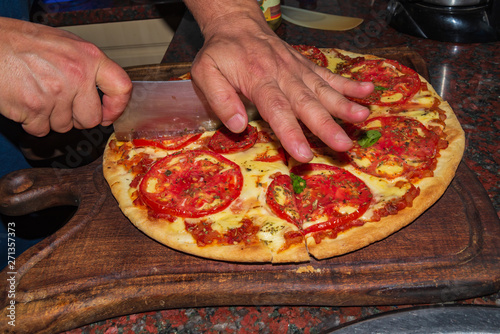 Pizza. Fresh Italian neapolitan, basil and tomato on a wooden table photo