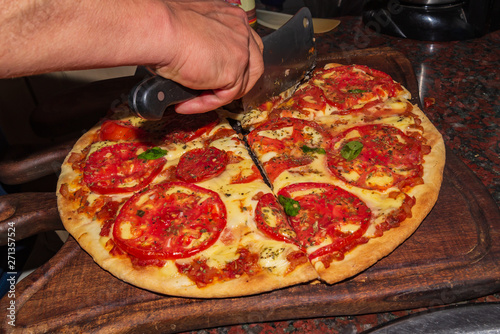 Pizza. Fresh Italian neapolitan, basil and tomato on a wooden table photo