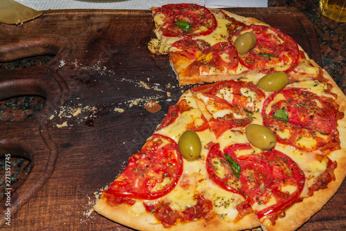 Pizza. Fresh Italian neapolitan, basil and tomato on a wooden table photo