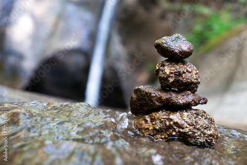 Four stones are arranged vertically and have flowing through the forest.