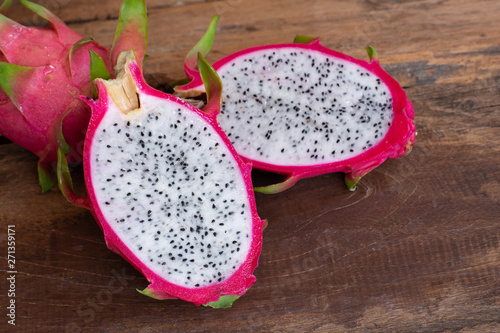 Organic white fresh dragon fruit cut into half on wooden chopping board