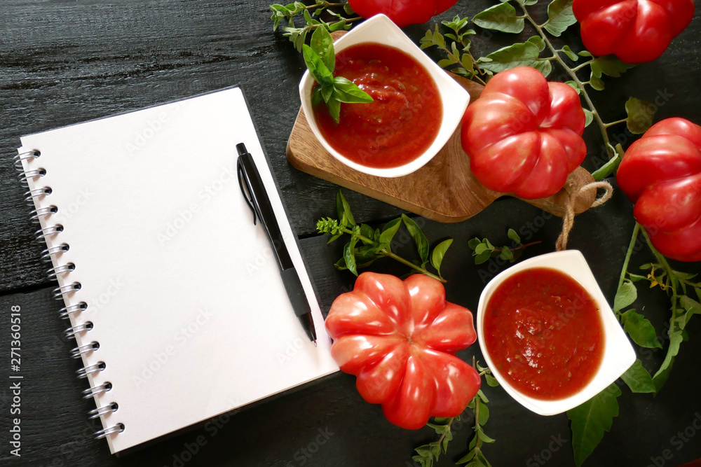 tomato sauce.Homemade tomato ketchup Homemade tomato ketchup, large ripe red tomatoes , white blank notebook on a black wooden background. Tomato Sauce Recipe