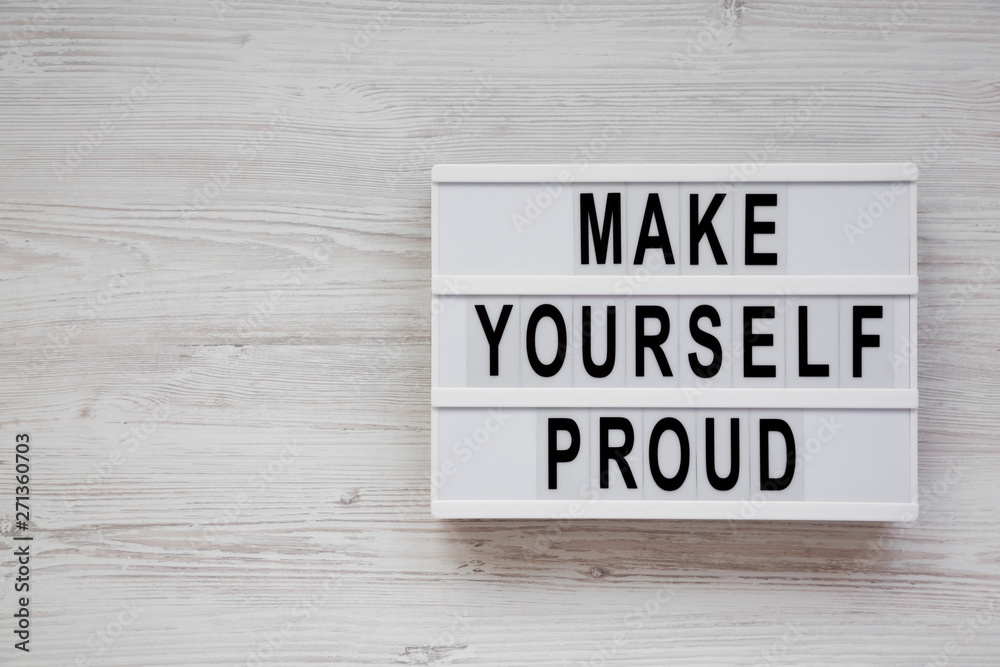 'Make yourself proud' words on a lightbox over white wooden surface, top view. Flat lay, top view, from above. Copy space. 'Make yourself proud' words on a lightbox over white wooden surface, top view. Flat lay, top view, from above. Copy space.
