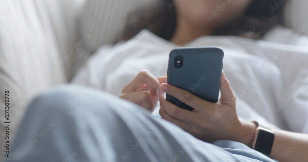 Woman use of smart phone and lying down on sofa