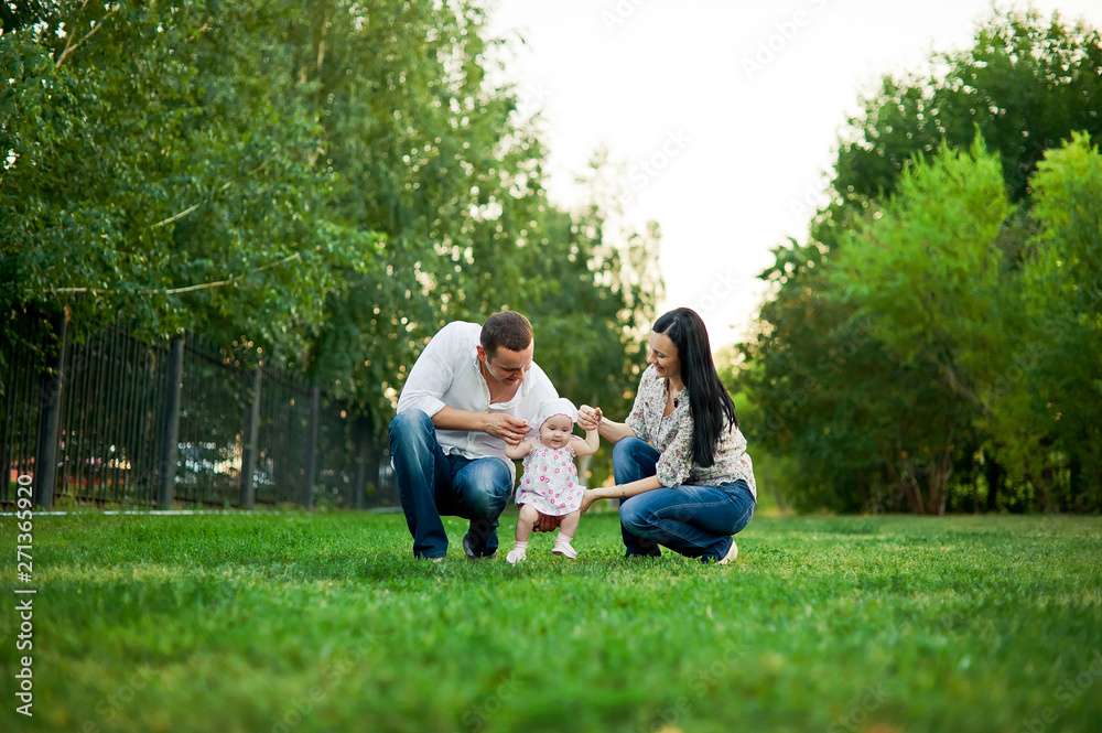 Happy family mother, father, child daughter. Happy young family spending time together outside in green nature. Happy family resting together on the green grass. Happy family having fun outdoors Happy family mother, father, child daughter. Happy young family spending time together outside in green nature. Happy family resting together on the green grass. Happy family having fun outdoors