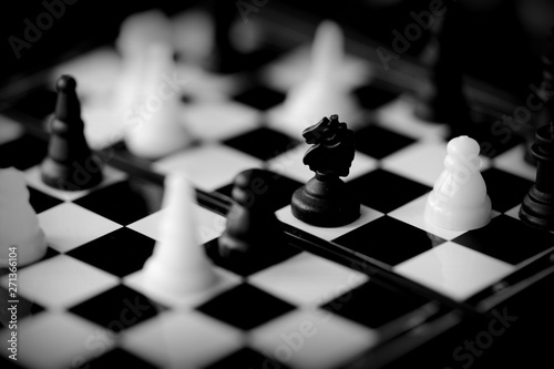 Travel Chess on a dark background close up. Black and white