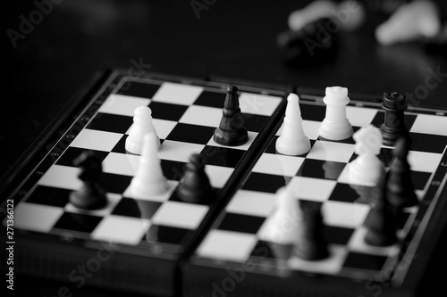 Travel Chess on a dark background close up. Black and white
