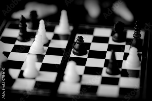 Travel Chess on a dark background close up. Black and white