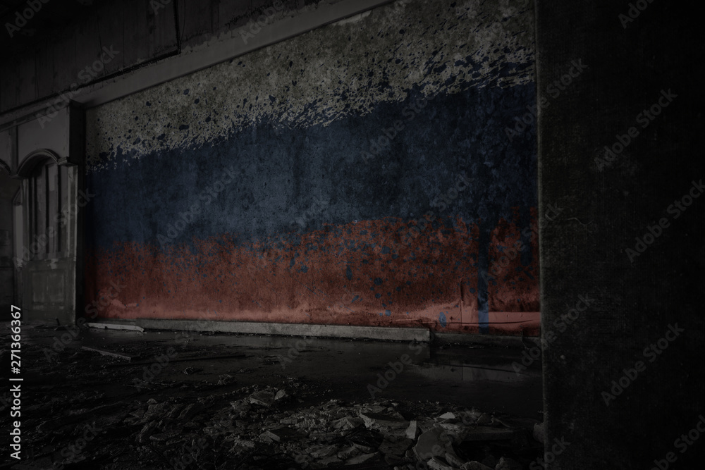 painted flag of russia on the dirty old wall in an abandoned ruined house.