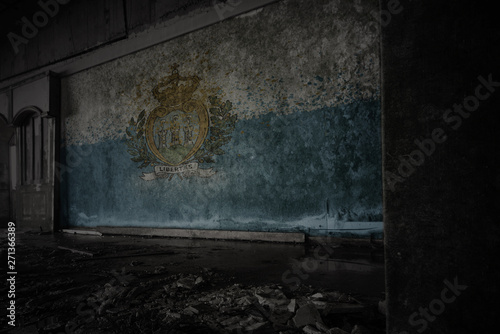 painted flag of san marino on the dirty old wall in an abandoned ruined house.