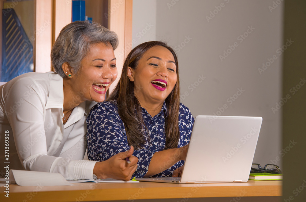 natural lifestyle portrait of two business partners or work colleagues women collaborating and coworking happy and cheerful at office laptop computer desk natural lifestyle portrait of two business partners or work colleagues women collaborating and coworking happy and cheerful at office laptop computer desk