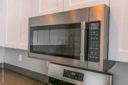 Close up of a microwave and white cabinets mounted on the wall of a kitchen
