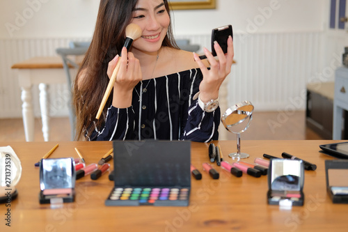 asian woman applying makeup cosmetic