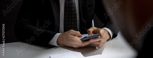 Konstfotografi Businessman texting on  mobile phone at the meeting in dark room