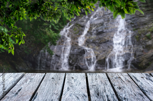Wooden table in green forest and Waterfall background,For product display. Beautiful.