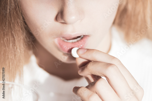medicine  health care and people concept - close up of woman taking in pill