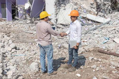Engineer architect and worker operation control demolish old building.