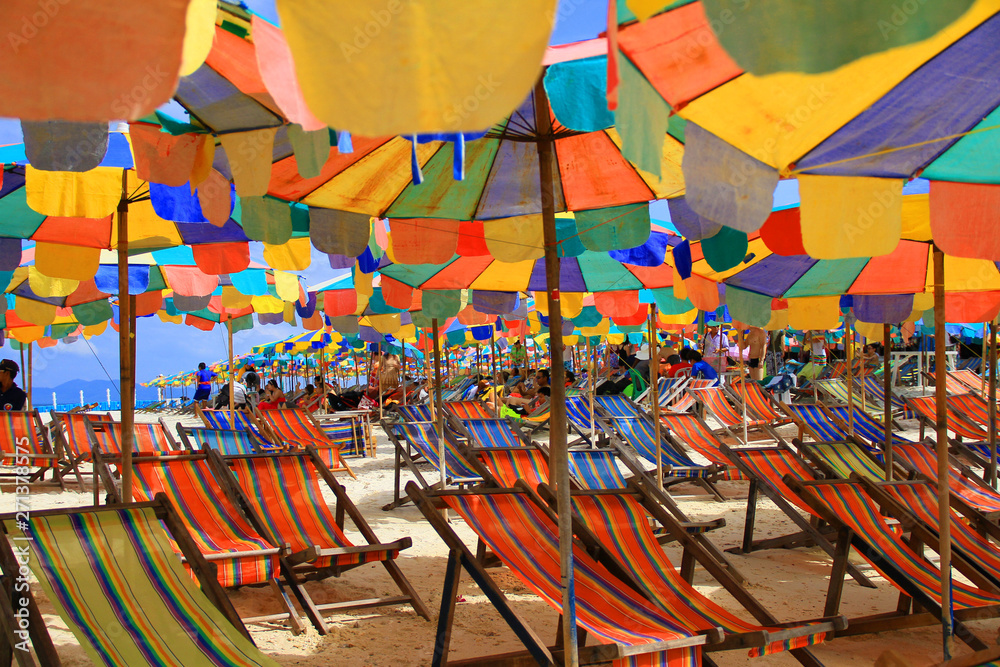 Koh Khai Nok, Phuket, Thailand - December 17, 2011: Many colorful umbrella and twin chair ready to serve for tourists to relaxing on the beach.