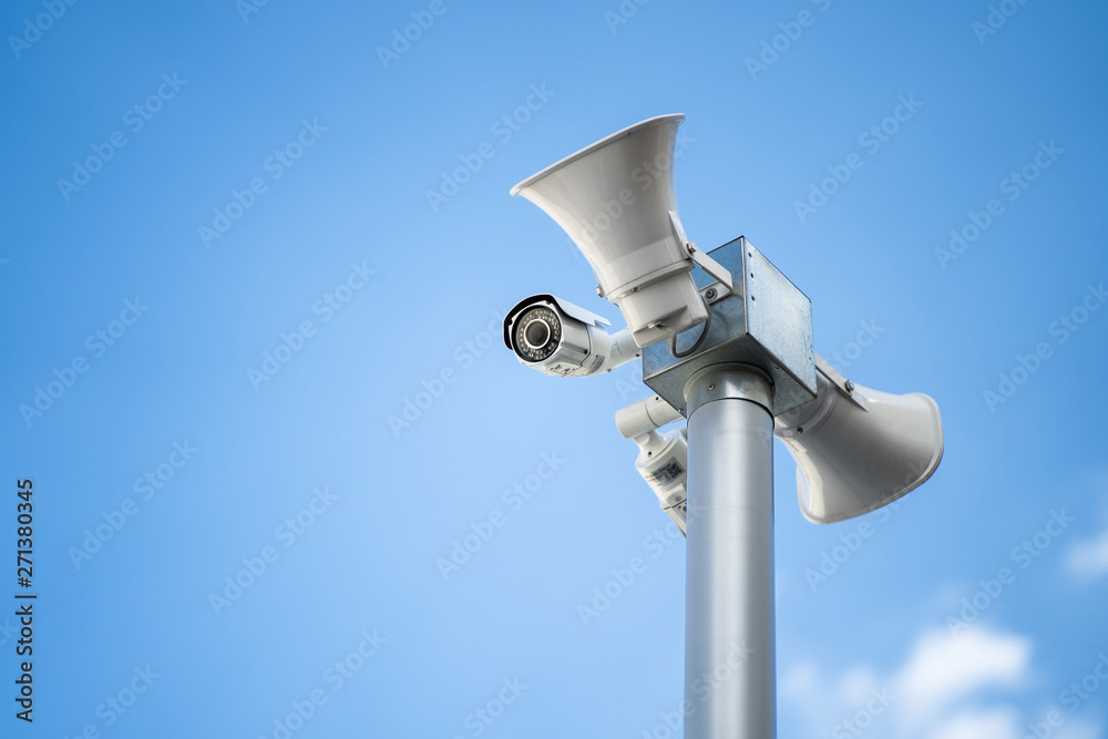 Security camera with loudspeakers and megaphone on the sky background Security camera with loudspeakers and megaphone on the sky background