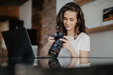 Young freelance woman photographer at home, working on laptop in home office
