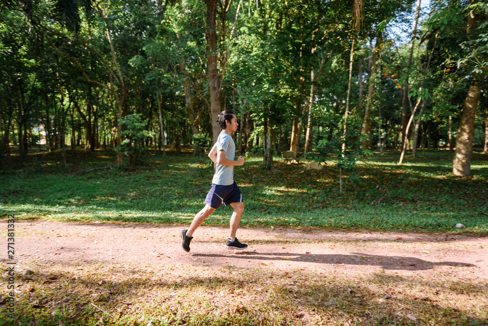 young man runner athlete running in a park young man runner athlete running in a park