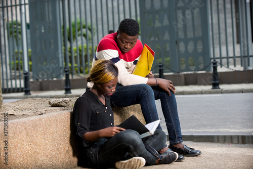 two young students reading their lessons outside