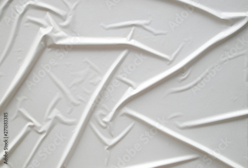 Decorative plaster imitating glued white paper on wall