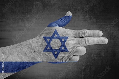 Israel flag painted flag  on male hand like a gun photo