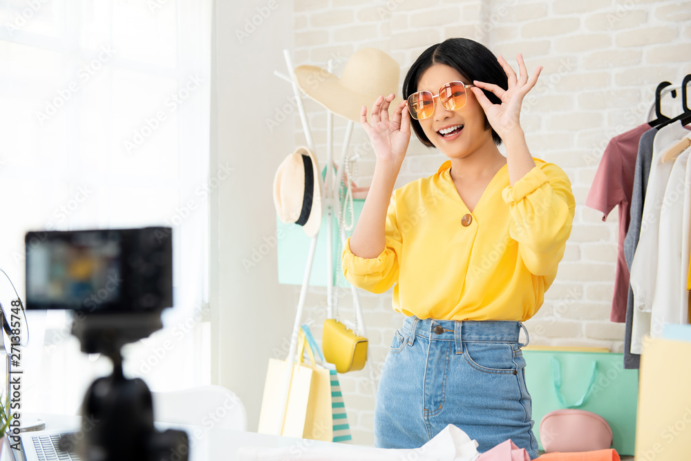 Young Asian woman fashion vlogger trying on clothes and accessories Young Asian woman fashion vlogger trying on clothes and accessories