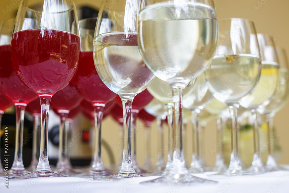 lot of blurred glasses with red and white wine on the reception party table lot of blurred glasses with red and white wine on the reception party table
