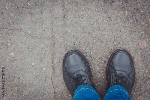 Men's leather shoes on the pavement, top view. Place for text at the top left.